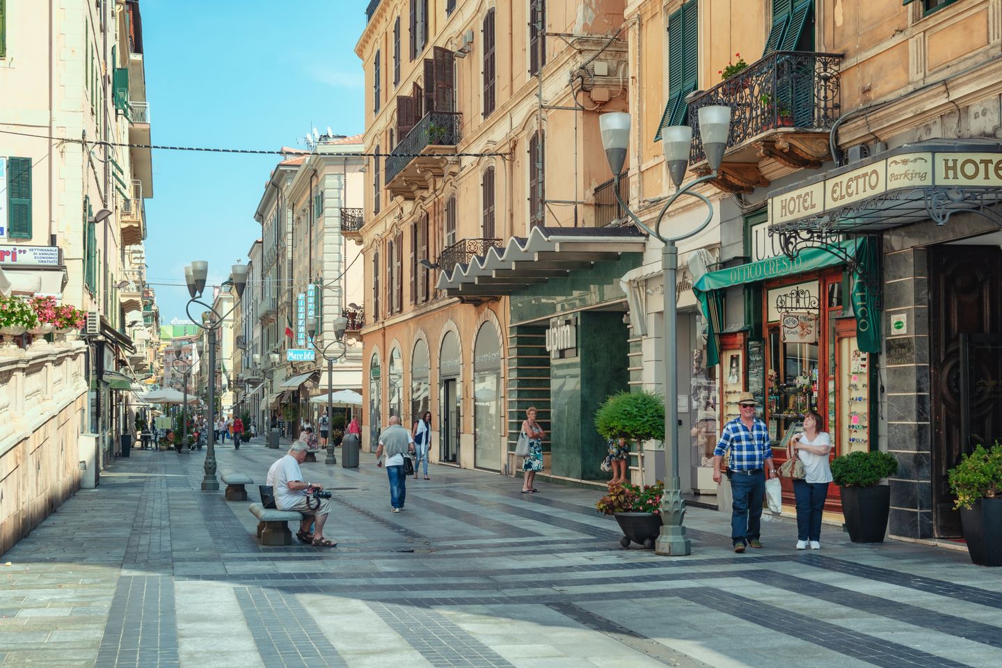 People walking down the street in San Remo, Italy, on a sunny day
